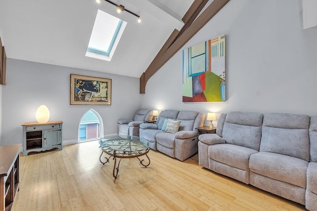 28 Broad St Unit 203, Marlborough, MA 01752 - living area featuring a skylight, track lighting, wood finished floors, high vaulted ceiling, and beam ceiling