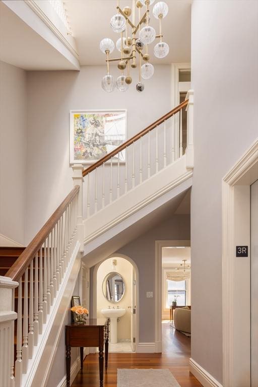 392 Marlborough St Unit 3, Boston, MA 02115 - interior space featuring baseboards, an inviting chandelier, wood finished floors, arched walkways, and a high ceiling