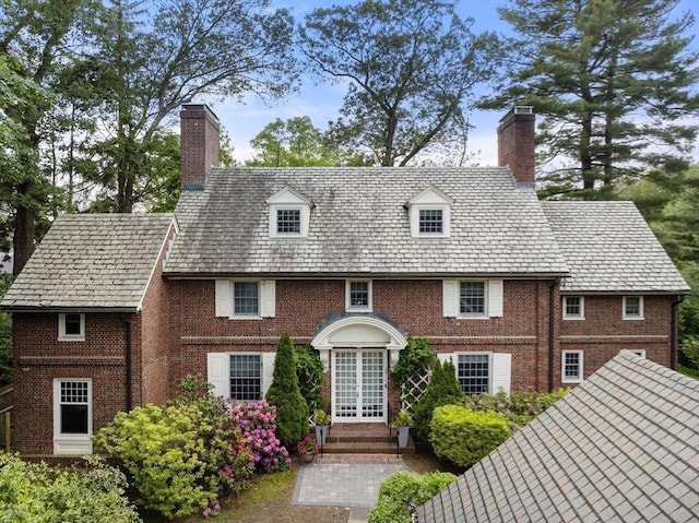 86 Waban Ave, Newton, MA 02468 - view of front facade featuring a chimney, a high end roof, and brick siding