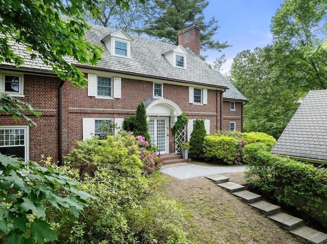 86 Waban Ave, Newton, MA 02468 - view of front of property with a chimney, a high end roof, and brick siding