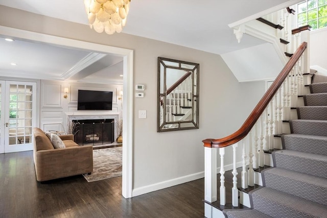 86 Waban Ave, Newton, MA 02468 - stairway with wood finished floors, a fireplace, ornamental molding, and a chandelier