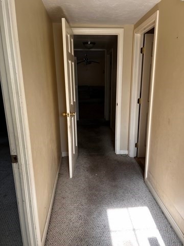 corridor featuring light carpet and a textured ceiling