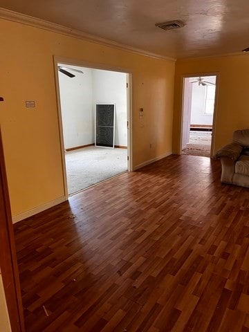 unfurnished living room with ceiling fan, dark hardwood / wood-style flooring, and ornamental molding