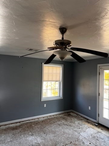 unfurnished room with ceiling fan and crown molding