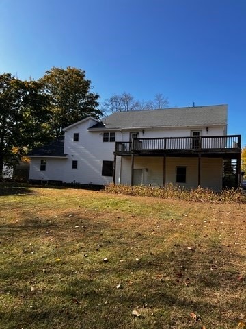 rear view of house featuring a yard and a deck