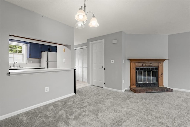 728 Auburn St Unit E4, Whitman, MA 02382 - kitchen with freestanding refrigerator, blue cabinetry, carpet, a chandelier, and a brick fireplace