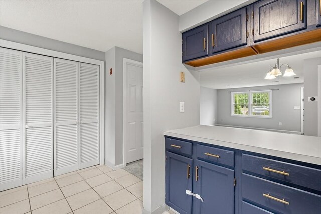 728 Auburn St Unit E4, Whitman, MA 02382 - kitchen featuring blue cabinetry, light tile patterned flooring, light countertops, and a chandelier