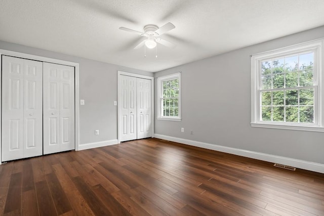 728 Auburn St Unit E4, Whitman, MA 02382 - unfurnished bedroom with multiple closets, dark wood-type flooring, and ceiling fan