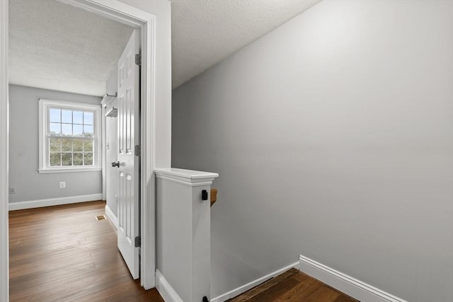 728 Auburn St Unit E4, Whitman, MA 02382 - corridor featuring a textured ceiling, dark wood finished floors, and an upstairs landing