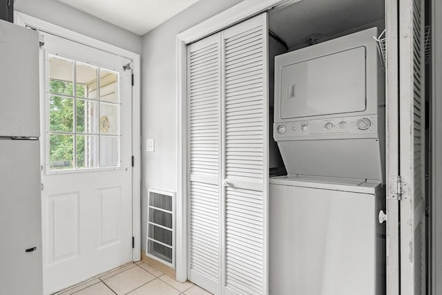 728 Auburn St Unit E4, Whitman, MA 02382 - laundry area with stacked washer / dryer and light tile patterned floors