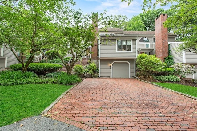 4 Benjamin Pl Unit 4, Brookline, MA 02467 - view of front of home featuring decorative driveway, a chimney, an attached garage, and a front yard