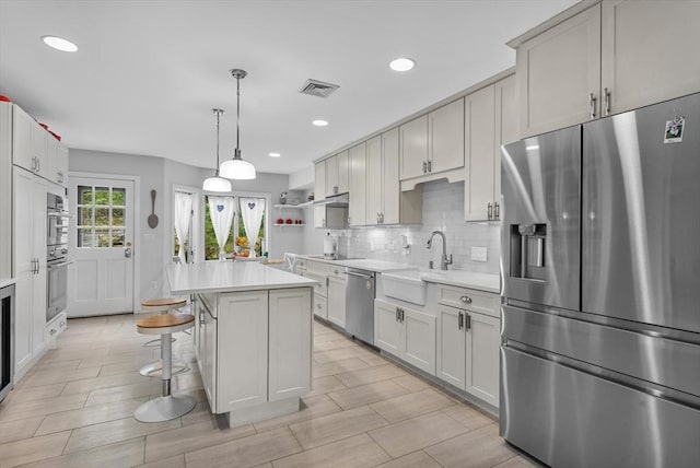 4 Benjamin Pl Unit 4, Brookline, MA 02467 - kitchen with stainless steel appliances, light countertops, open shelves, a center island, and tasteful backsplash