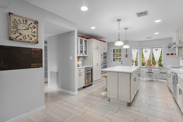 4 Benjamin Pl Unit 4, Brookline, MA 02467 - kitchen featuring beverage cooler, a center island, light countertops, white cabinetry, and recessed lighting