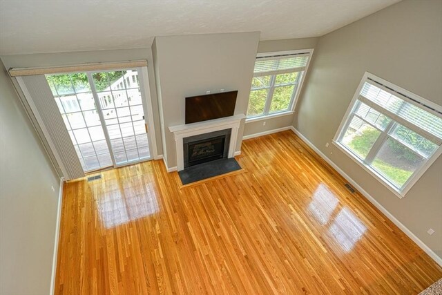 39 Balancing Rock Dr Unit 39, Holliston, MA 01746 - unfurnished living room with light wood-style floors and a fireplace with flush hearth