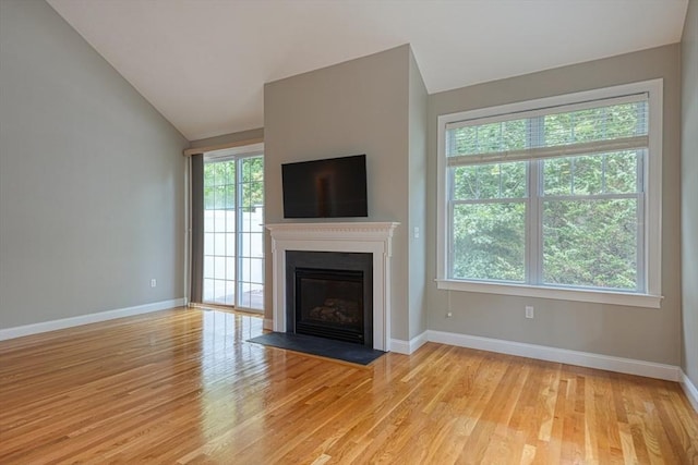39 Balancing Rock Dr Unit 39, Holliston, MA 01746 - unfurnished living room with vaulted ceiling, light wood-type flooring, and a fireplace with flush hearth