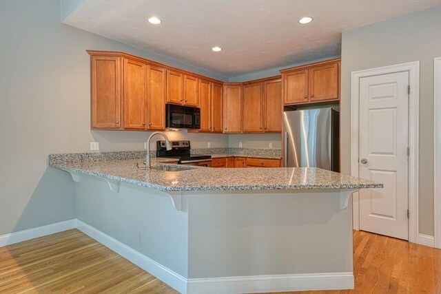 39 Balancing Rock Dr Unit 39, Holliston, MA 01746 - kitchen featuring stainless steel appliances, a peninsula, light wood finished floors, brown cabinets, and recessed lighting