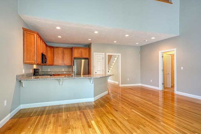 39 Balancing Rock Dr Unit 39, Holliston, MA 01746 - kitchen with stainless steel refrigerator, black microwave, a peninsula, recessed lighting, and light wood finished floors
