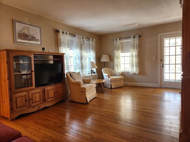 sitting room with hardwood / wood-style floors and a healthy amount of sunlight