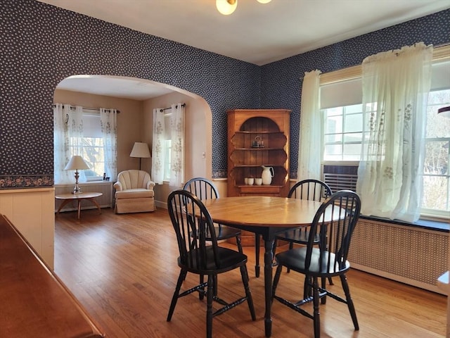 dining room featuring cooling unit, hardwood / wood-style floors, and radiator heating unit