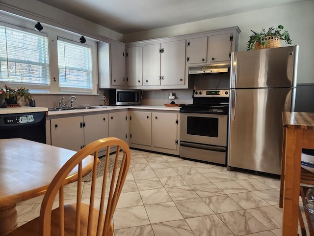 kitchen featuring stainless steel appliances, sink, and backsplash