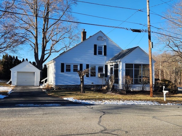 view of front of home with cooling unit, a garage, an outdoor structure, and a sunroom