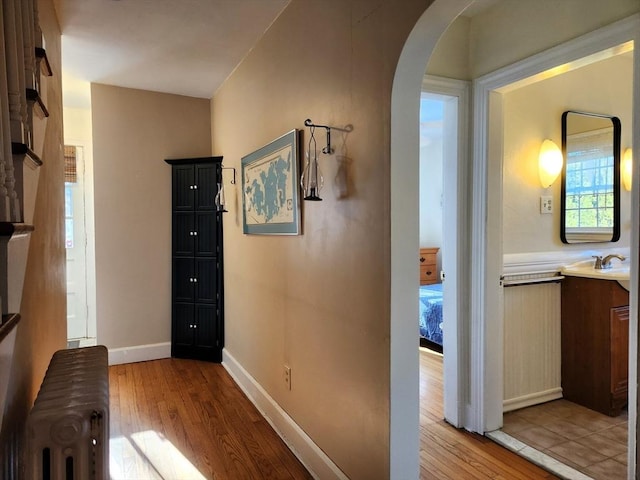 hallway with radiator and light hardwood / wood-style floors