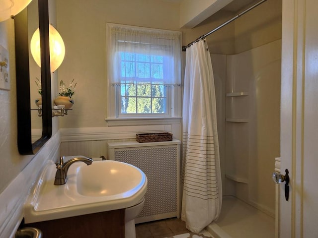 bathroom featuring vanity, radiator, tile patterned floors, and walk in shower