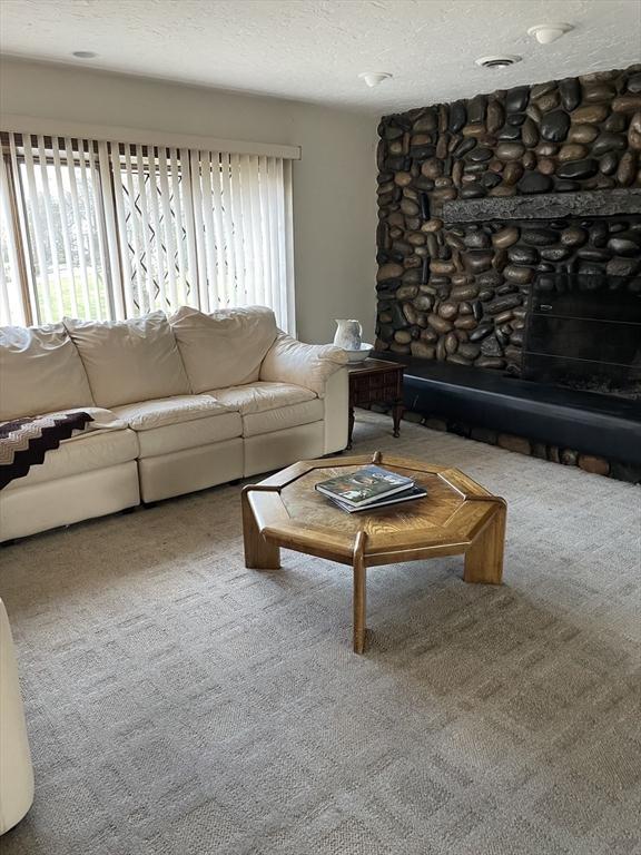 carpeted living area featuring visible vents and a textured ceiling