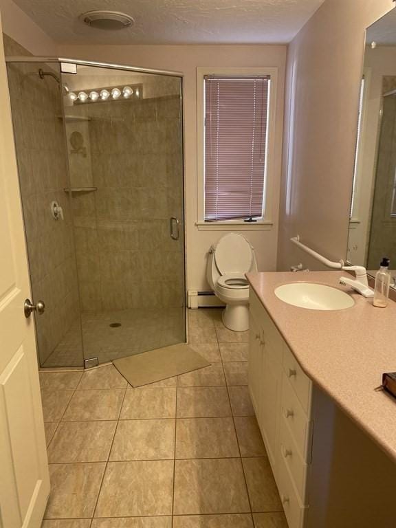 full bathroom with a baseboard heating unit, toilet, a shower stall, and a textured ceiling