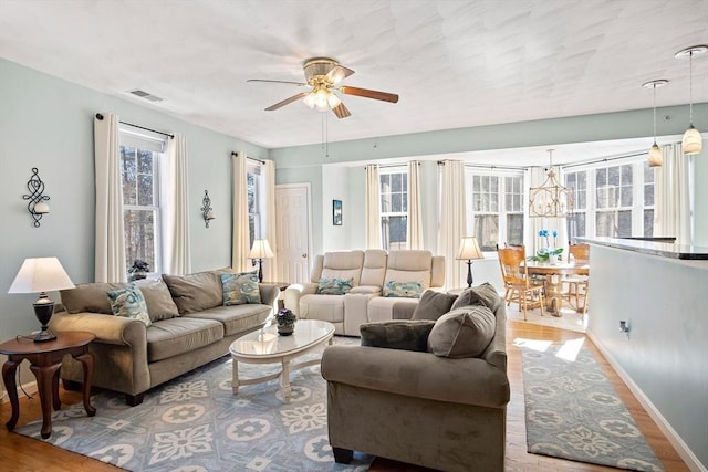 living room featuring hardwood / wood-style floors and ceiling fan with notable chandelier