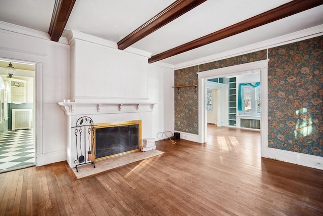 unfurnished living room featuring ornamental molding, beamed ceiling, and hardwood / wood-style floors