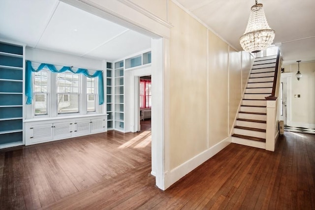 stairway featuring hardwood / wood-style flooring, built in shelves, an inviting chandelier, and radiator