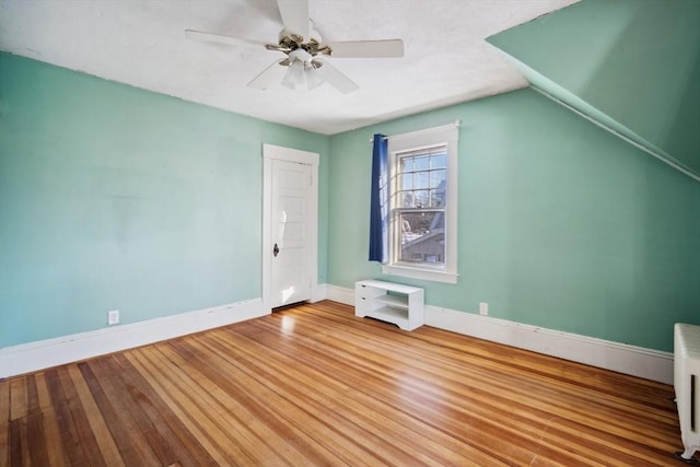 additional living space with lofted ceiling, hardwood / wood-style flooring, and ceiling fan