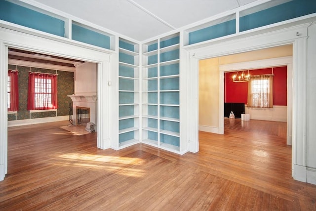 unfurnished room featuring a notable chandelier and wood-type flooring