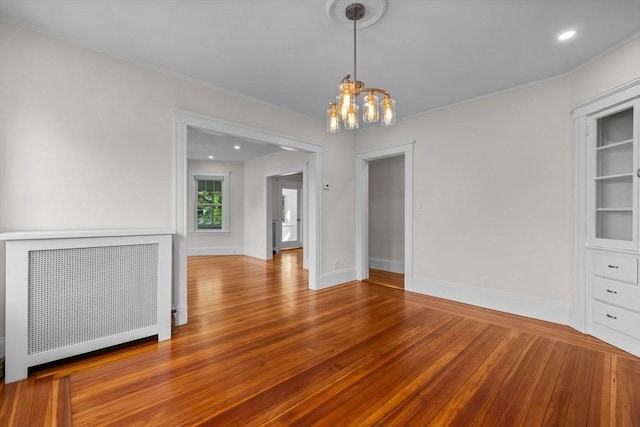 37 Fountain Rd Unit 2, Arlington, MA 02476 - spare room with radiator heating unit, a chandelier, wood finished floors, baseboards, and ornamental molding