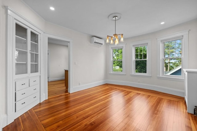37 Fountain Rd Unit 2, Arlington, MA 02476 - unfurnished dining area featuring an AC wall unit, baseboards, a chandelier, wood-type flooring, and recessed lighting