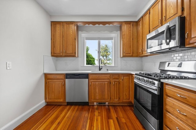 37 Fountain Rd Unit 2, Arlington, MA 02476 - kitchen with stainless steel appliances, a sink, dark wood finished floors, and brown cabinetry