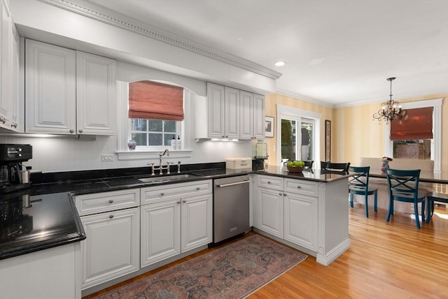 kitchen with plenty of natural light, a sink, dishwasher, and a notable chandelier