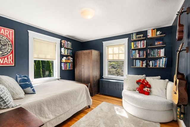 bedroom featuring wood finished floors and radiator