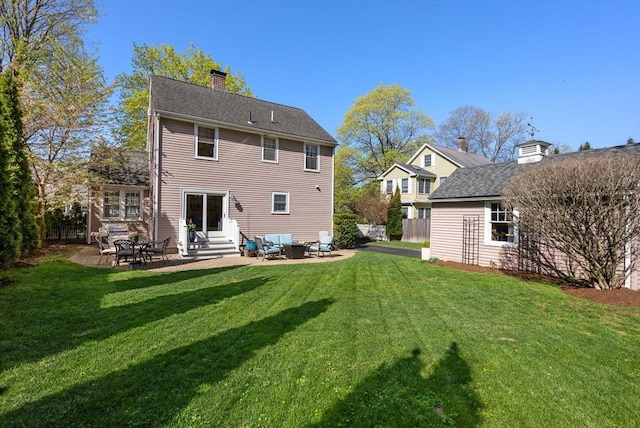 back of property with a yard, a chimney, a patio area, and entry steps