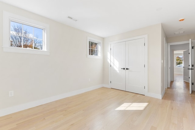 unfurnished bedroom featuring light hardwood / wood-style flooring and a closet