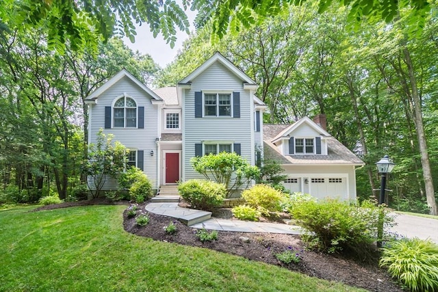 traditional home with a front lawn, a garage, driveway, and a chimney