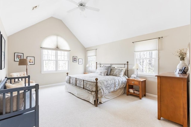 bedroom featuring vaulted ceiling, light colored carpet, visible vents, and multiple windows