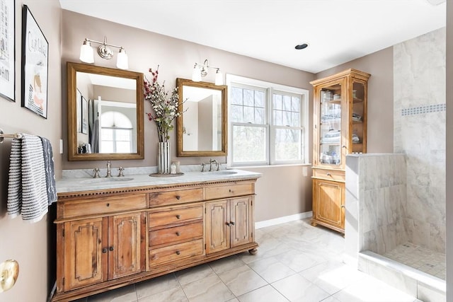 full bath featuring double vanity, baseboards, walk in shower, and a sink