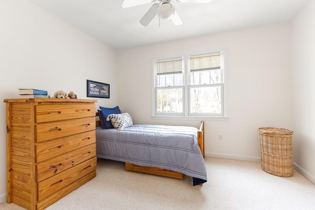 bedroom featuring light carpet, a ceiling fan, and baseboards