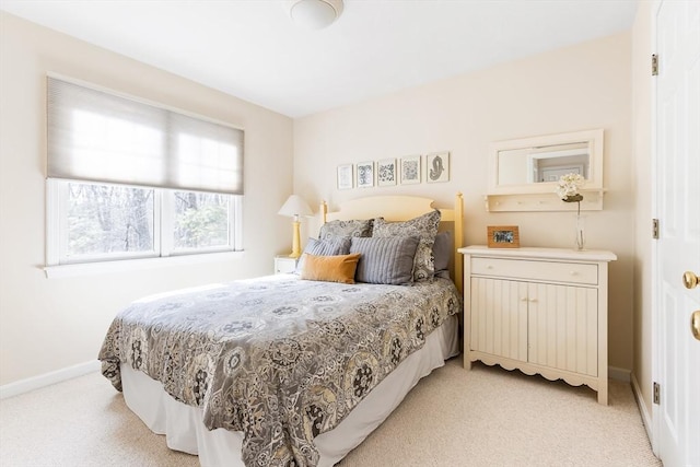 bedroom with baseboards and light carpet