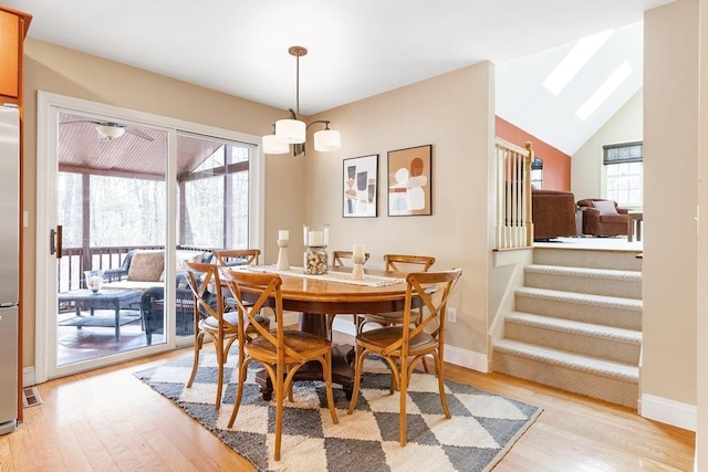 dining room featuring lofted ceiling, light wood finished floors, and a wealth of natural light