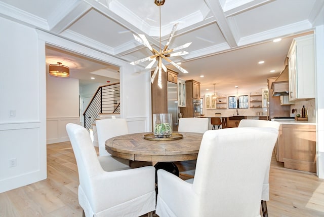 dining room with beamed ceiling, light wood-type flooring, crown molding, and coffered ceiling