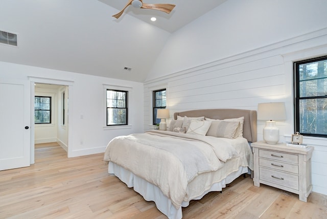 bedroom with light wood-type flooring and high vaulted ceiling