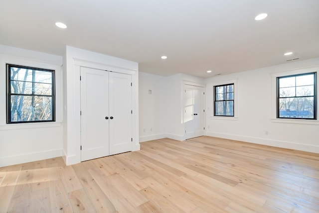 unfurnished room featuring light wood-type flooring and a wealth of natural light